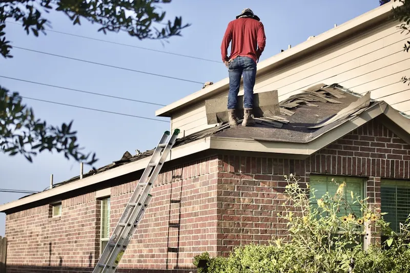 Professional roofer working on a residential roof in Stewart Manor